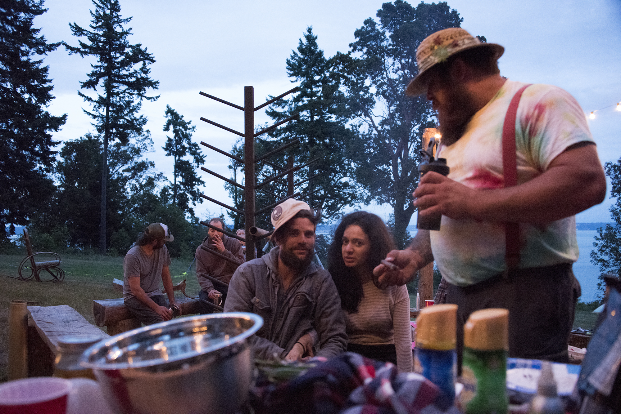 Trav, Milla, and Nate (of Titan Leathers) sharing some treats in the camp kitchen. The kitchen being a fireside gathering space, for water views, live music, food, conversation, and warmth | photo: Illes Austin Illes Photography x Toebock American Folklore